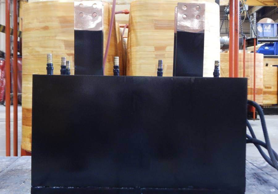 High-frequency industrial transformer with copper terminals mounted in a manufacturing environment, designed for power electronics applications.